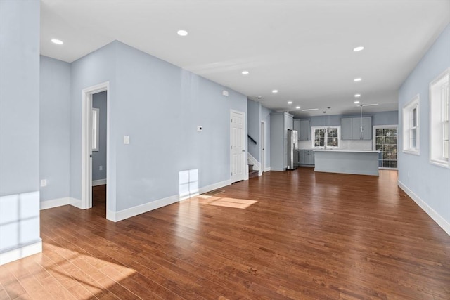 unfurnished living room with dark wood-type flooring