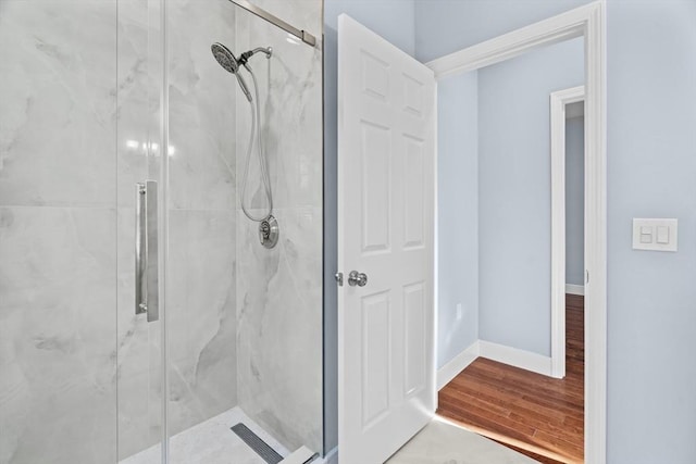 bathroom with wood-type flooring and a shower with door