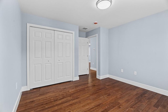 unfurnished bedroom featuring dark hardwood / wood-style floors and a closet