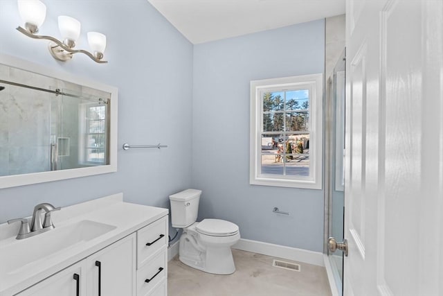 bathroom featuring tile patterned flooring, vanity, toilet, and walk in shower