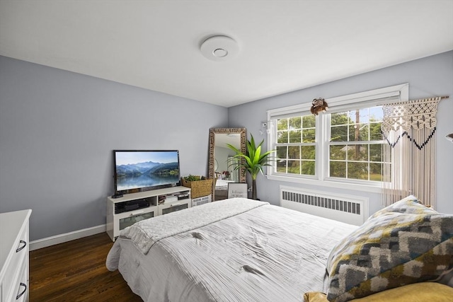 bedroom with baseboards, radiator heating unit, and dark wood-type flooring