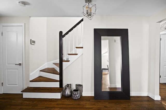 staircase featuring wood finished floors and baseboards