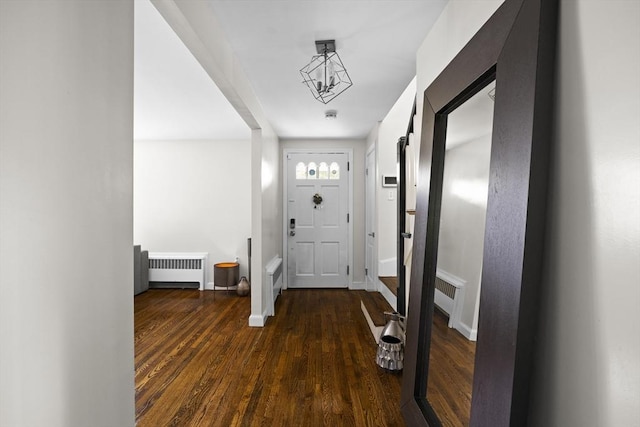 foyer entrance with hardwood / wood-style floors, radiator heating unit, and baseboards