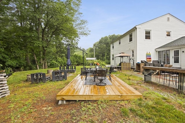 wooden deck featuring a lawn and outdoor dining area