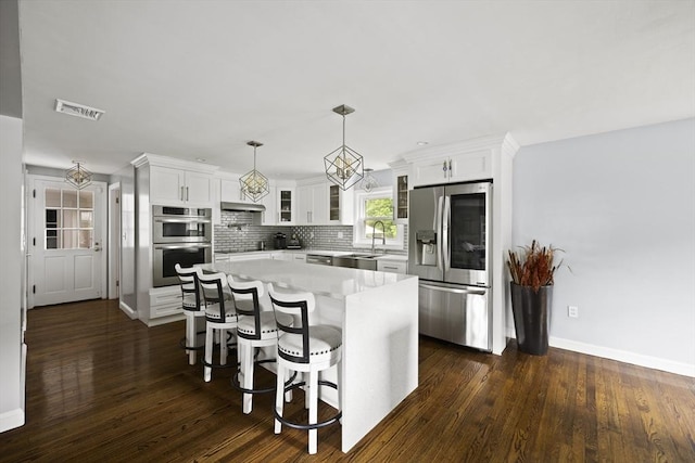 kitchen featuring white cabinetry, glass insert cabinets, appliances with stainless steel finishes, and light countertops