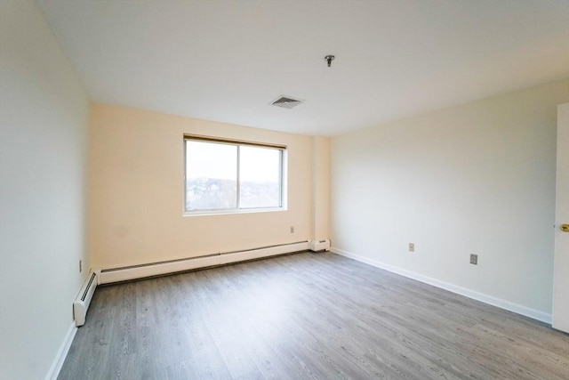 spare room with hardwood / wood-style flooring and baseboard heating