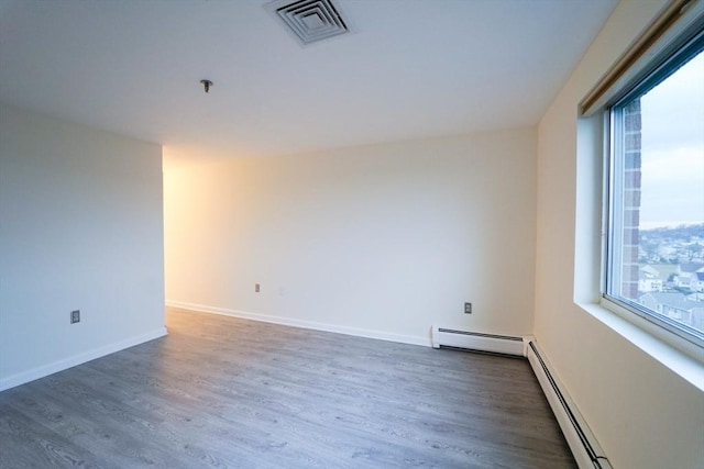 unfurnished room with dark hardwood / wood-style flooring and a baseboard radiator