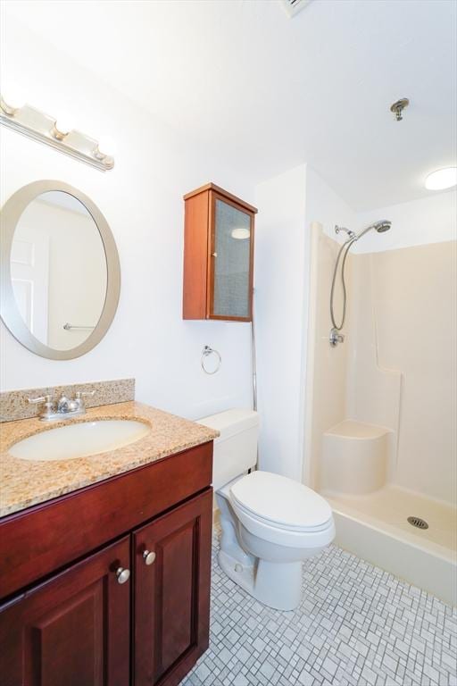 bathroom with tile patterned floors, vanity, toilet, and walk in shower