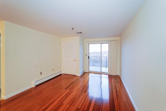 unfurnished room with hardwood / wood-style floors and baseboard heating