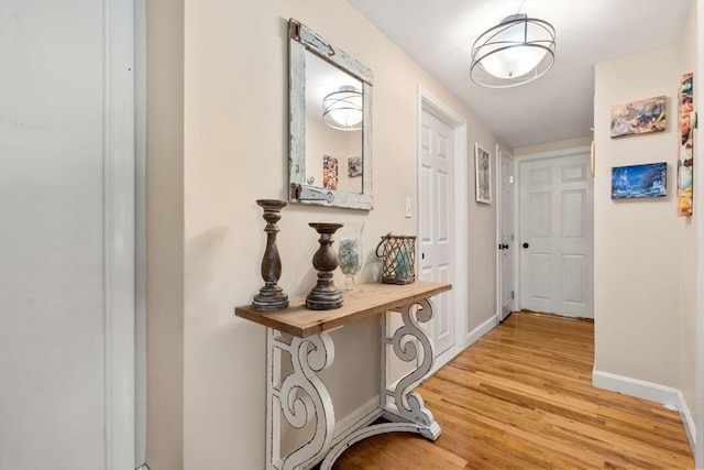 hall with light wood finished floors and baseboards