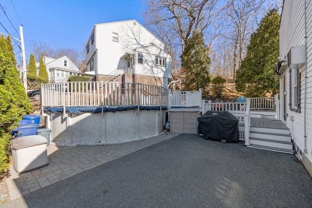 view of patio / terrace with a covered pool, grilling area, and a wooden deck