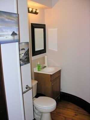 bathroom with vanity, toilet, and hardwood / wood-style floors