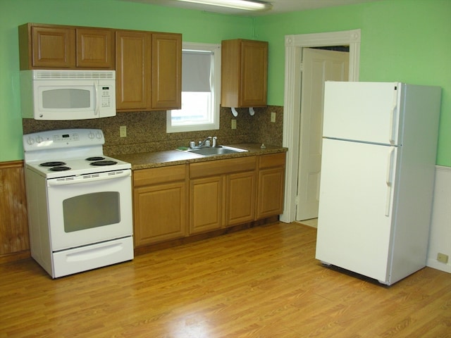 kitchen with light hardwood / wood-style flooring, sink, white appliances, and tasteful backsplash