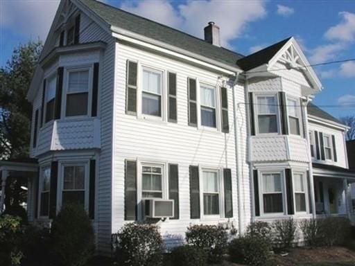 view of property exterior featuring cooling unit and a chimney