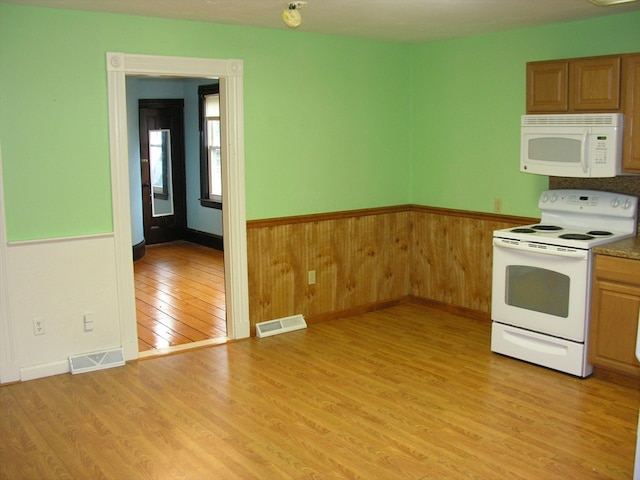 kitchen with white appliances and light hardwood / wood-style floors