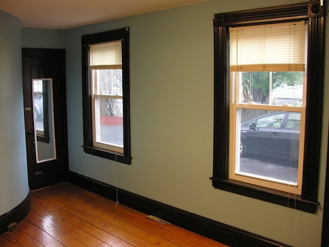 unfurnished room with hardwood / wood-style flooring