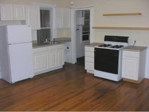 kitchen with white cabinetry, white appliances, dark hardwood / wood-style flooring, and sink