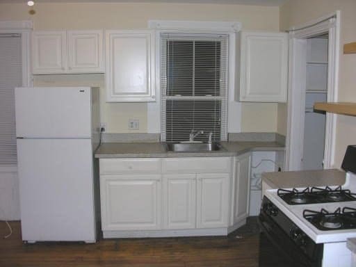 kitchen with dark hardwood / wood-style floors, sink, white appliances, and white cabinetry