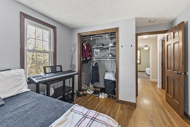 bedroom with light hardwood / wood-style floors and a closet