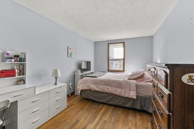 bedroom featuring hardwood / wood-style flooring and a textured ceiling