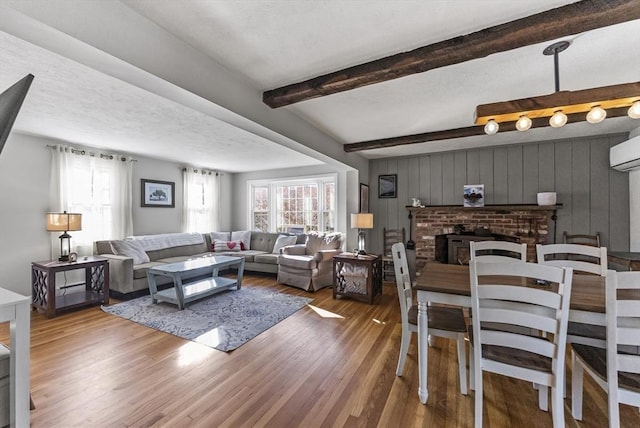 living room featuring wood-type flooring, a fireplace, beam ceiling, and wood walls