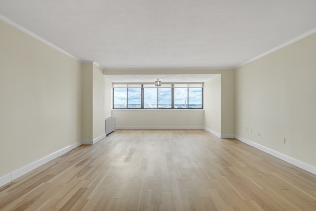 spare room featuring crown molding and light hardwood / wood-style floors