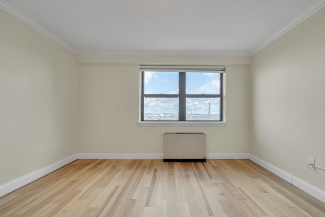 empty room with radiator heating unit, light hardwood / wood-style floors, and ornamental molding