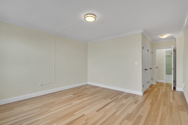 empty room featuring crown molding and light wood-type flooring