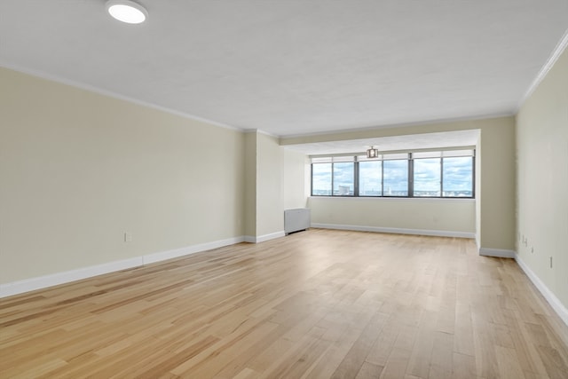 empty room featuring ornamental molding and light wood-type flooring