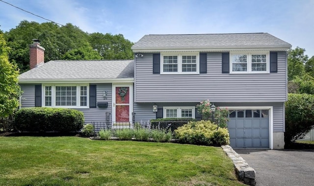 28 Foster Dr, Framingham, MA 01701 - tri-level home featuring a garage, a front yard, asphalt driveway, and a chimney