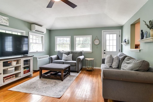 28 Foster Dr, Framingham, MA 01701 - living area featuring an AC wall unit, radiator heating unit, plenty of natural light, a ceiling fan, and vaulted ceiling