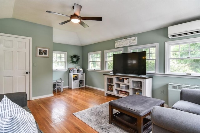 28 Foster Dr, Framingham, MA 01701 - living area featuring an AC wall unit, wood finished floors, vaulted ceiling, radiator, and a ceiling fan