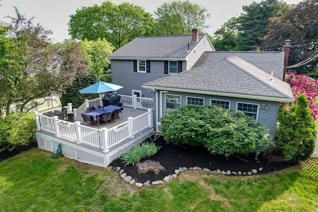 28 Foster Dr, Framingham, MA 01701 - back of house with a shingled roof, a yard, a chimney, a wooden deck, and outdoor dining space
