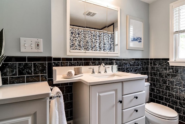 28 Foster Dr, Framingham, MA 01701 - bathroom with tile walls, vanity, toilet, and wainscoting