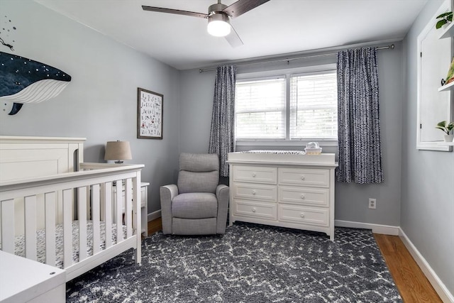 28 Foster Dr, Framingham, MA 01701 - bedroom featuring a nursery area, dark wood-style flooring, baseboards, and ceiling fan