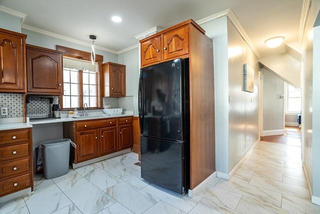 350 Wentworth Ave, Lowell, MA 01852 - kitchen with freestanding refrigerator, a sink, light marble finish flooring, brown cabinetry, and baseboards