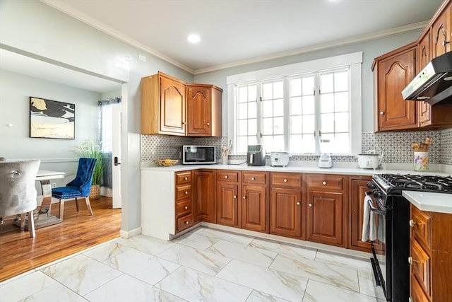 350 Wentworth Ave, Lowell, MA 01852 - kitchen with black range with gas stovetop, under cabinet range hood, stainless steel microwave, light marble finish flooring, and crown molding