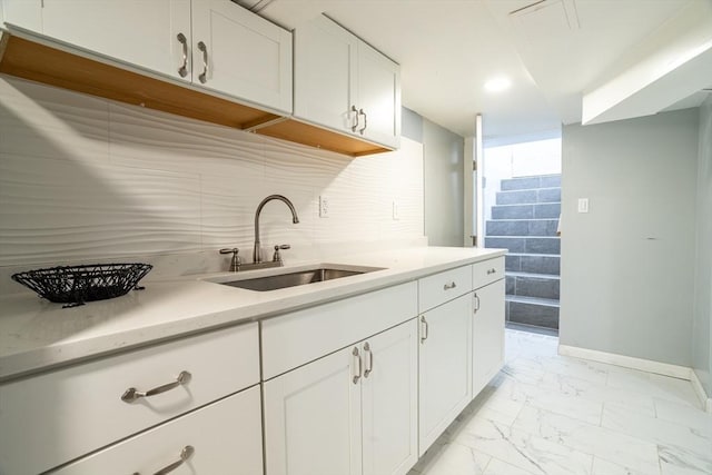 350 Wentworth Ave, Lowell, MA 01852 - kitchen featuring a sink, light marble finish flooring, baseboards, white cabinetry, and light countertops