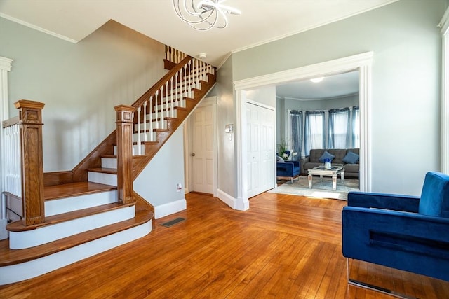 350 Wentworth Ave, Lowell, MA 01852 - staircase featuring hardwood / wood-style flooring, crown molding, a chandelier, and baseboards