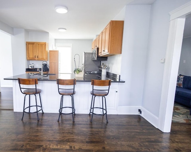 14 Fales St, Worcester, MA 01606 - kitchen with a peninsula, dark countertops, dark wood-style floors, and a sink