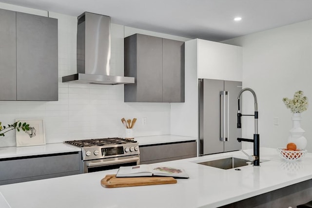 kitchen featuring appliances with stainless steel finishes, wall chimney range hood, light countertops, and recessed lighting