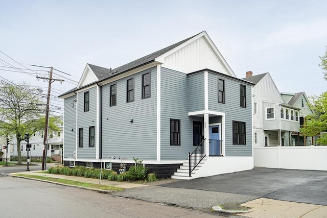 view of front of house with board and batten siding and fence