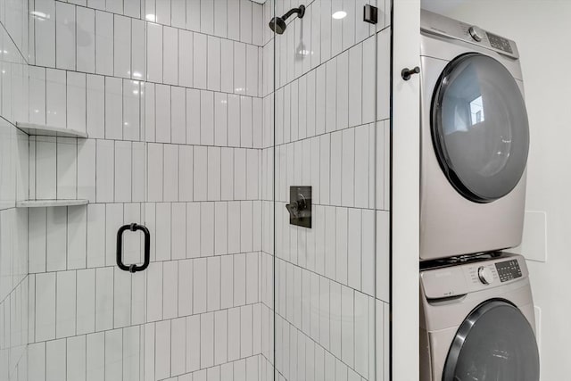 full bathroom featuring stacked washing machine and dryer and a shower stall