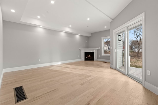 unfurnished living room featuring light hardwood / wood-style flooring and plenty of natural light