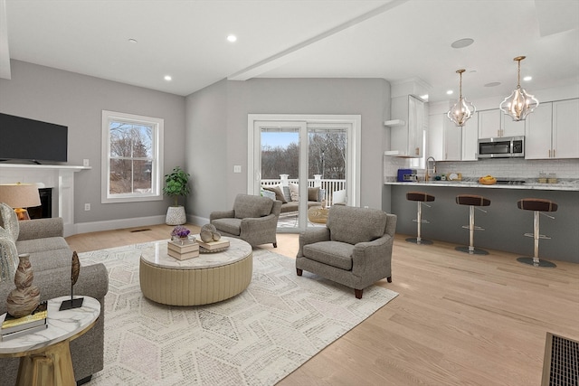 living room featuring light hardwood / wood-style floors, sink, and plenty of natural light