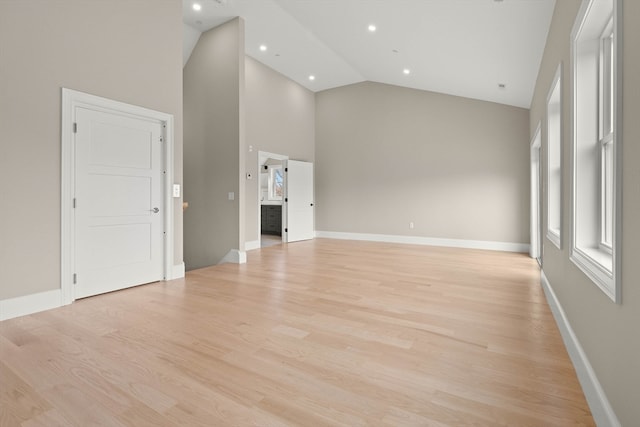 unfurnished living room with light hardwood / wood-style flooring and high vaulted ceiling