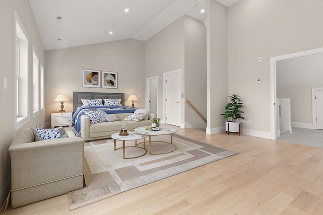 bedroom featuring light hardwood / wood-style flooring and high vaulted ceiling