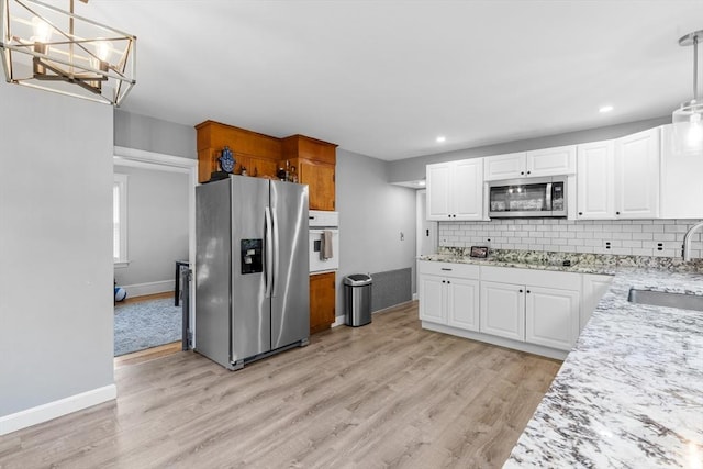 190 Winthrop St, Taunton, MA 02780 - kitchen featuring appliances with stainless steel finishes, backsplash, light wood finished floors, white cabinets, and recessed lighting