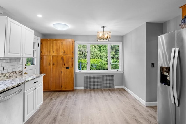 190 Winthrop St, Taunton, MA 02780 - kitchen featuring stainless steel appliances, radiator heating unit, light wood-style flooring, light stone counters, and white cabinetry
