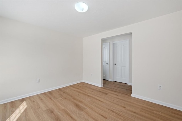 unfurnished room featuring light wood finished floors and baseboards